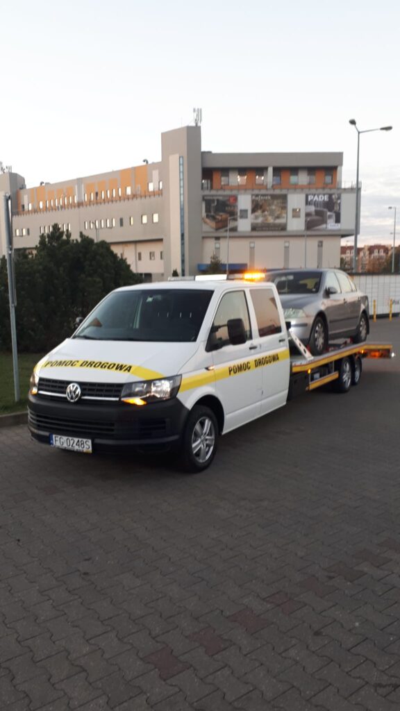 Laweta Hannover transportująca uszkodzony pojazd w centrum miasta, szybka i niezawodna pomoc na drodze.