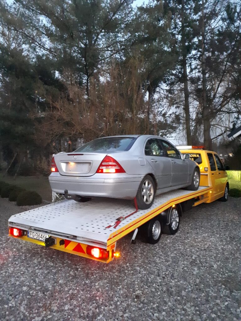 Laweta Hannover holująca uszkodzony samochód na autostradzie, zapewniając szybką i bezpieczną pomoc drogową.